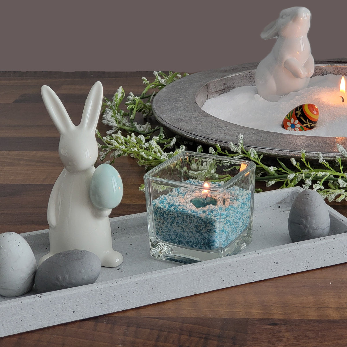 Kerzensand 2 Farben gemischt umrahmt mit einer Oster-Deko bestehend aus Osterhase und verzierte Beton-Eier